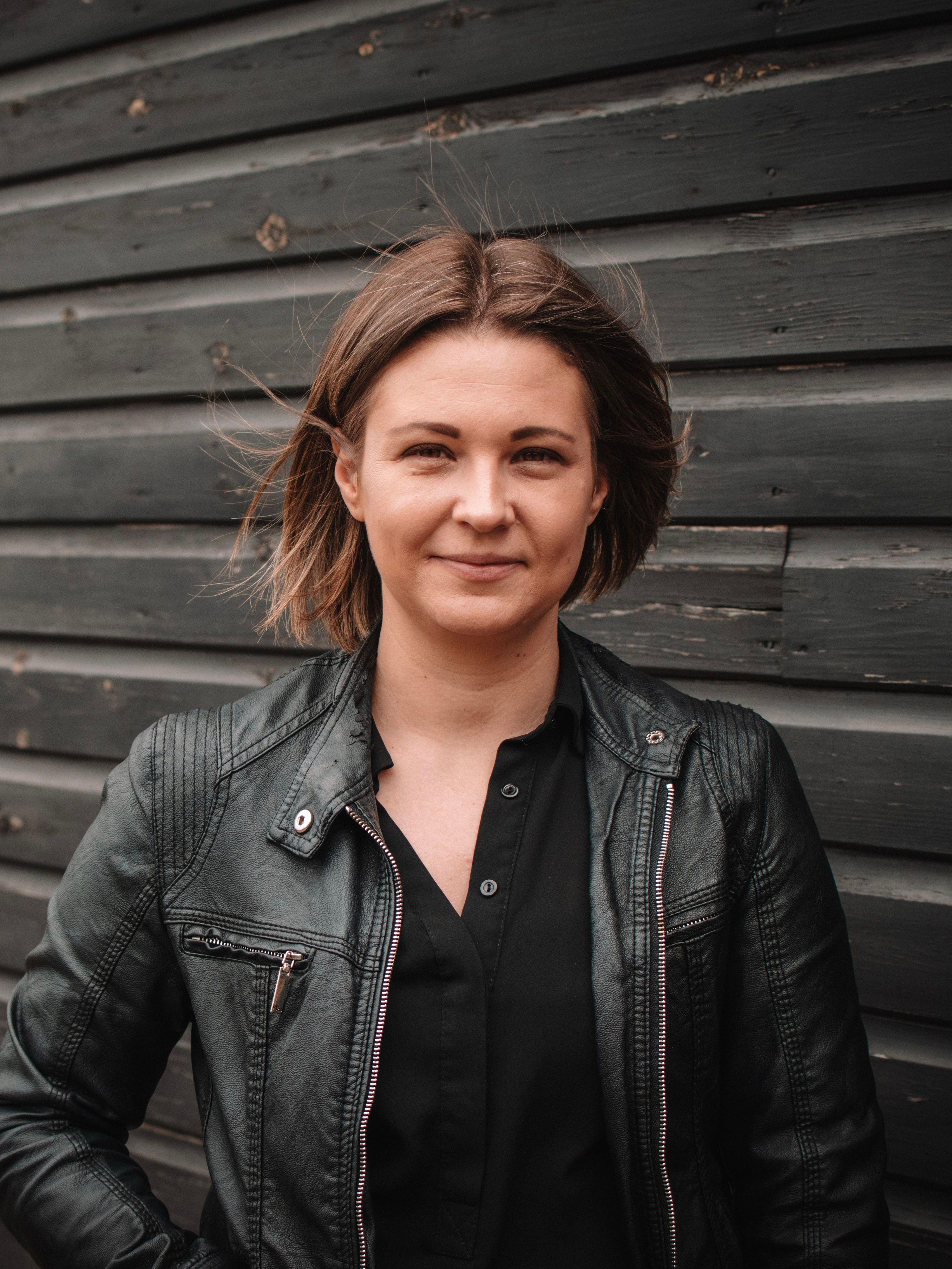 Freestyle Managing Director Emma Simkiss smiling in front of a black wooden wall.